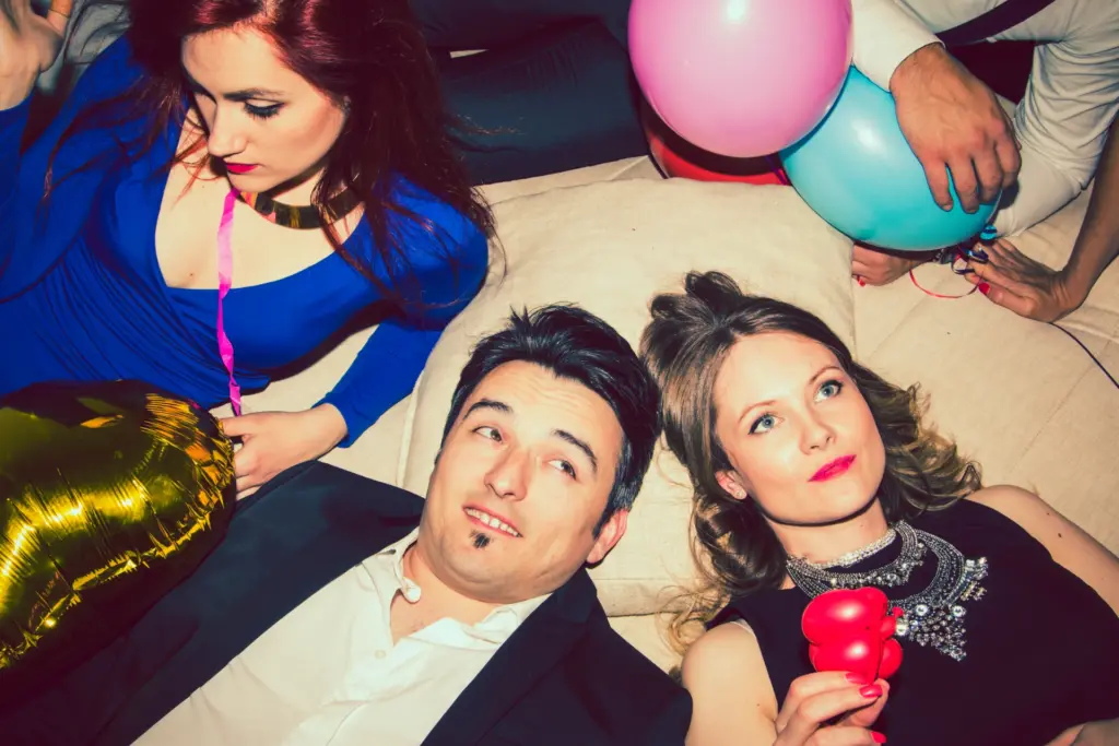 1 Mann und zwei Frauen mit einem Rosa und Türkisblauen Luftballon.