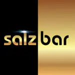 Das Bild zeigt das Wort salzbar in fetten, goldenen Buchstaben. Der Hintergrund ist vertikal geteilt: die linke Hälfte ist schwarz hinter salz, die rechte Hälfte ist gold hinter bar. Über dem "l" erscheint eine helle Fackel.